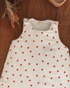 Gigoteuse Ninona en double gaze de coton blanche à cœurs rouges, confectionnée à la main en France. Ultra tendance et cocooning, elle offre confort et sécurité au sommeil de bébé. Idéale pour la chambre de bébé en hiver, cette gigoteuse artisanale séduit les futurs parents en quête d’un accessoire doux, fait main et élégant.