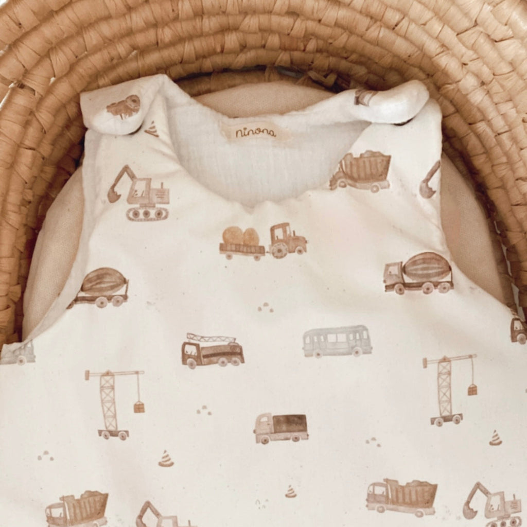 gigoteuse personnalisable fait à la main pour bébé garçon avec des motifs de tracteurs. cette gigoteuse est personnalisable, ce qui en fait une belle idée de cadeau de naissance. Cette gigoteuse est réalisable en version été, mi saison et hiver. Elle conviendras dès la naissance de bébé. Cette gigoteuse est blanche et les motifs de tracteurs et engins de chantier sont marrons. création originale ninona, 