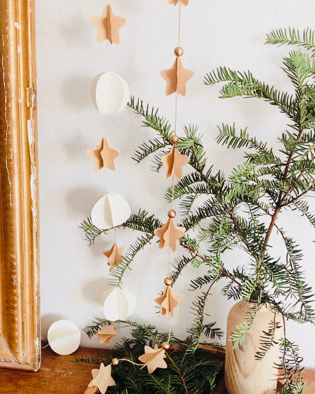 Guirlande faite main formée d’étoiles en papier kraft et de sphères blanches, attachées avec soin sur un fil très discret intégrant de petites LED chaleureuses. Le papier plié crée des volumes élégants qui tamisent la lumière. Cette création artisanale offre un style naturel et minimaliste, parfait pour décorer un intérieur, apporter une touche poétique ou embellir une ambiance douce et raffinée. ninona