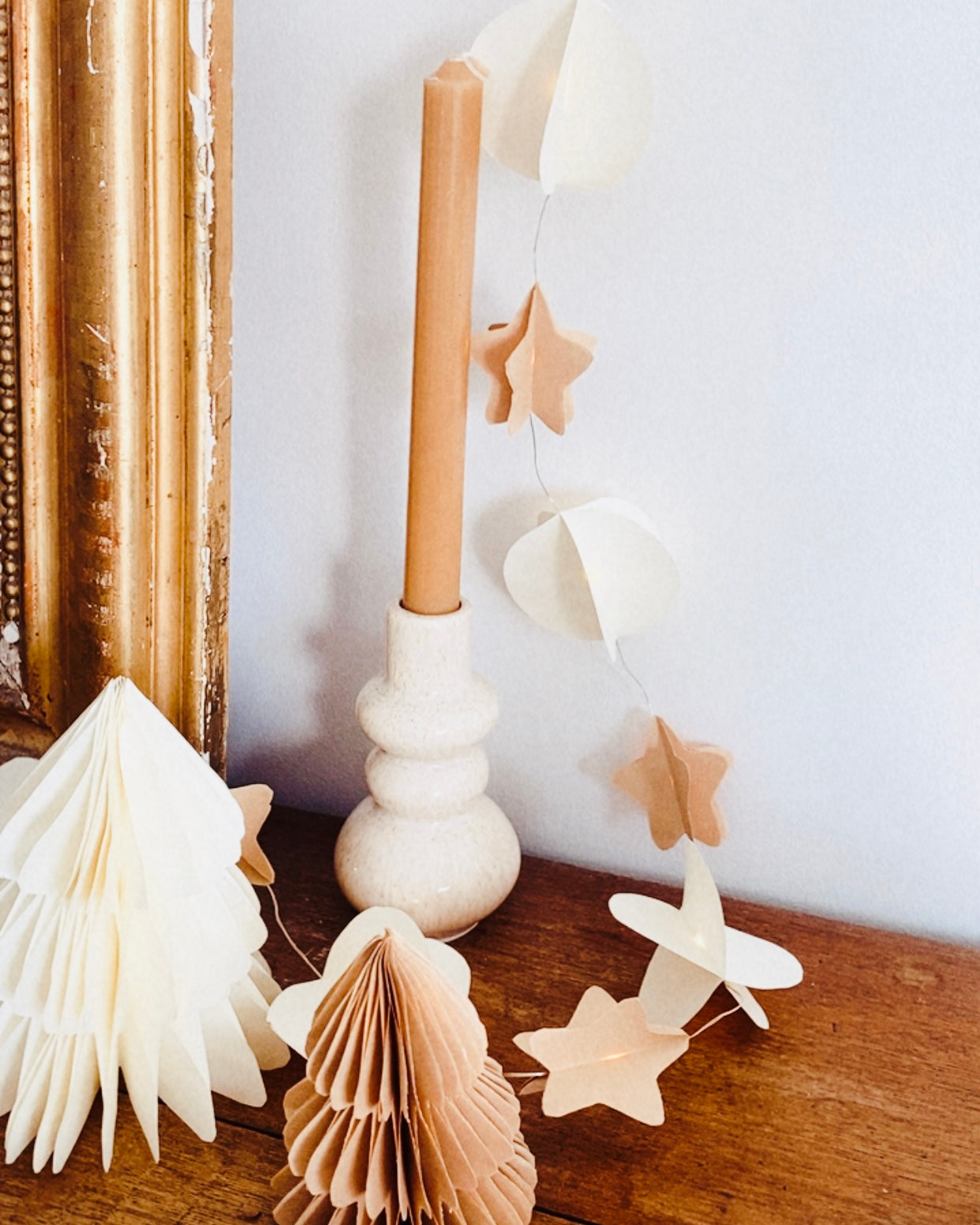 Cette guirlande lumineuse confectionnée à la main associe élégamment des étoiles en papier kraft et des sphères blanches légères. Chaque pièce est pliée avec soin pour créer du volume et laisser filtrer la lumière des petites LED insérées le long du fil. Le résultat est une décoration douce, chaleureuse et naturelle, qui s’intègre parfaitement aux ambiances épurées ou inspirées du fait main. ninona