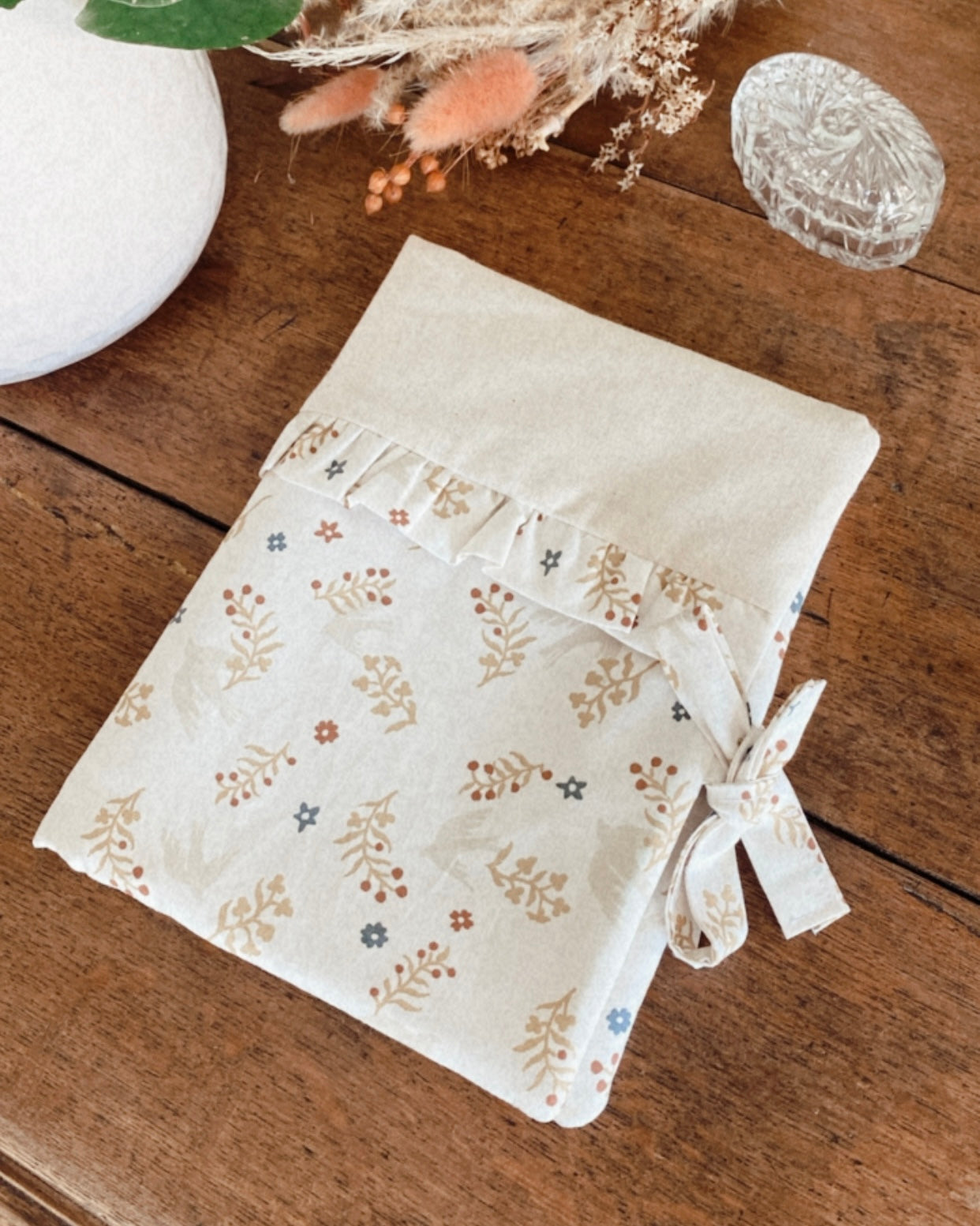 protège carnet de santé personnalisable, dans les tons beiges et écru. De jolis froufrou ajoutent une touche de poèsie à cette housse de carnet de santé. Des motifs fleuris et des petites hirondelles rendent ce protège carnet idéale comme cadeau de naissance pour une petite fille.