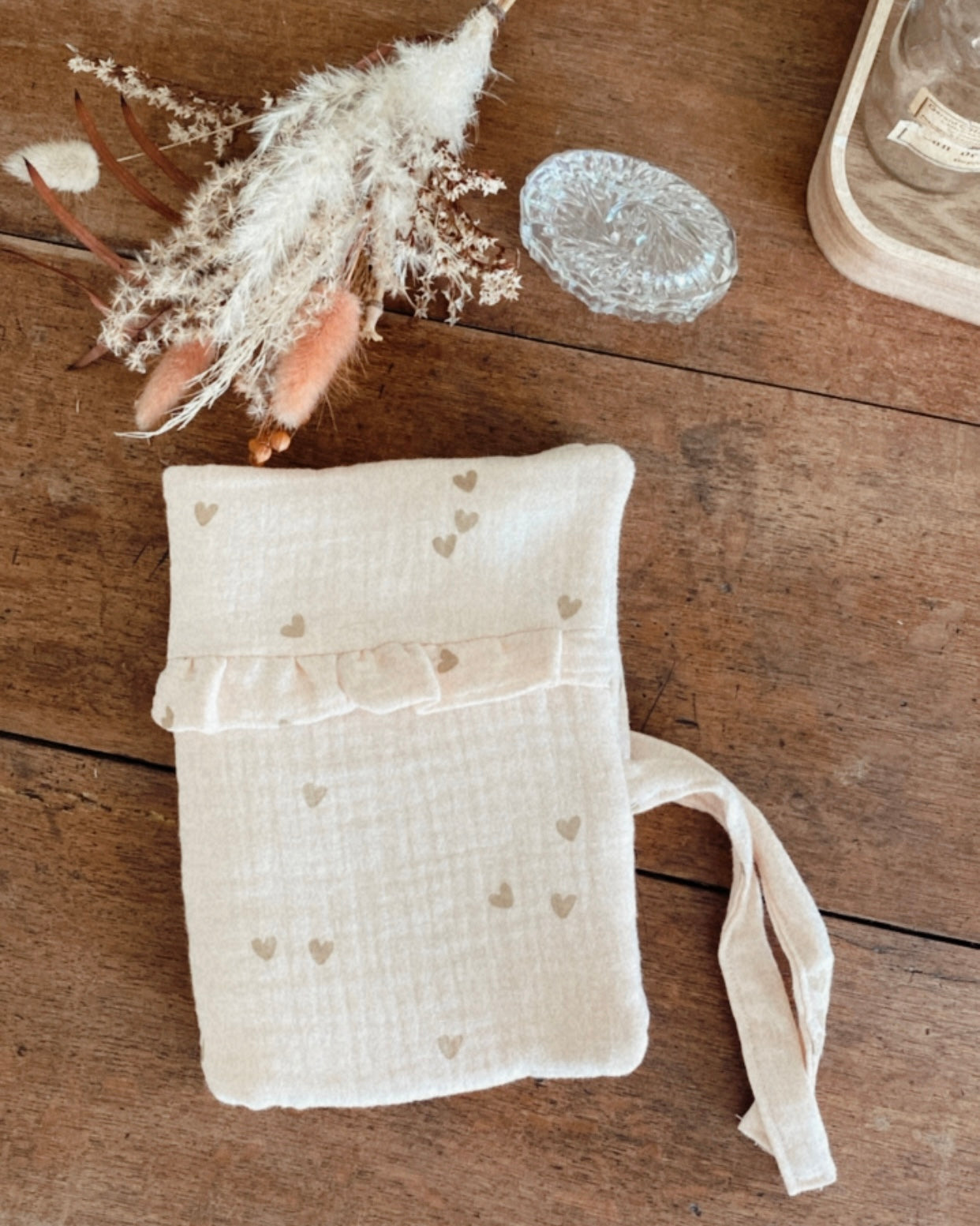 protège carnet de santé personnalisable, dans les tons beiges et écru. Cette housse de carnet de sante personnalisable est réalisée avec une double gaze de coton, avec des petits coeurs dorés.  De jolis froufrou ajoutent une touche de poèsie à cette housse de carnet de santé. Idéal comme cadeau de naissance pour une petite fille.