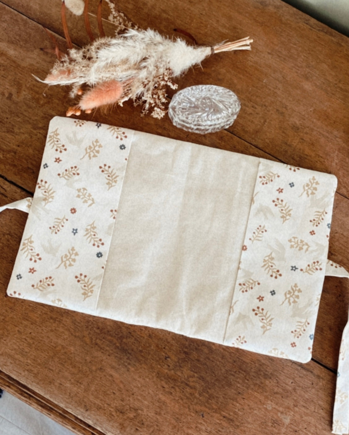 protège carnet de santé personnalisable, dans les tons beiges et écru. De jolis froufrou ajoutent une touche de poèsie à cette housse de carnet de santé. Des motifs fleuris et des petites hirondelles rendent ce protège carnet idéale comme cadeau de naissance pour une petite fille.