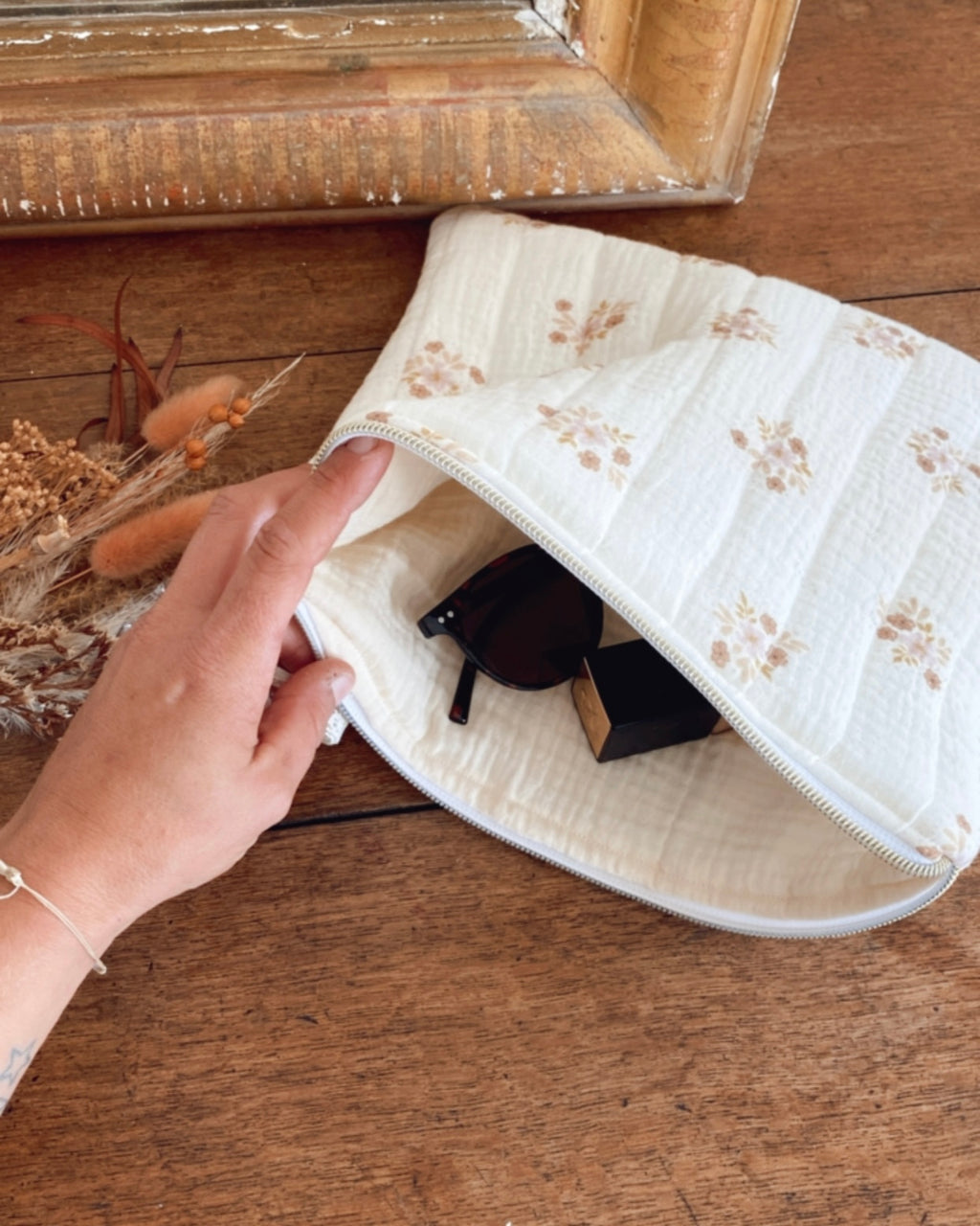 Pochette féminine et raffinée faite main en coton écru fleuri, au style bohème chic. Conçue pour garder vos indispensables du quotidien à portée de main : maquillage, bijoux, accessoires de beauté ou petits carnets. Sa fabrication artisanale française garantit une pièce unique et durable. Cadeau idéal pour femme, à offrir pour toutes les occasions spéciales. Une pochette pratique et élégante qui ajoute une touche de douceur à la vie quotidienne. création originale ninona